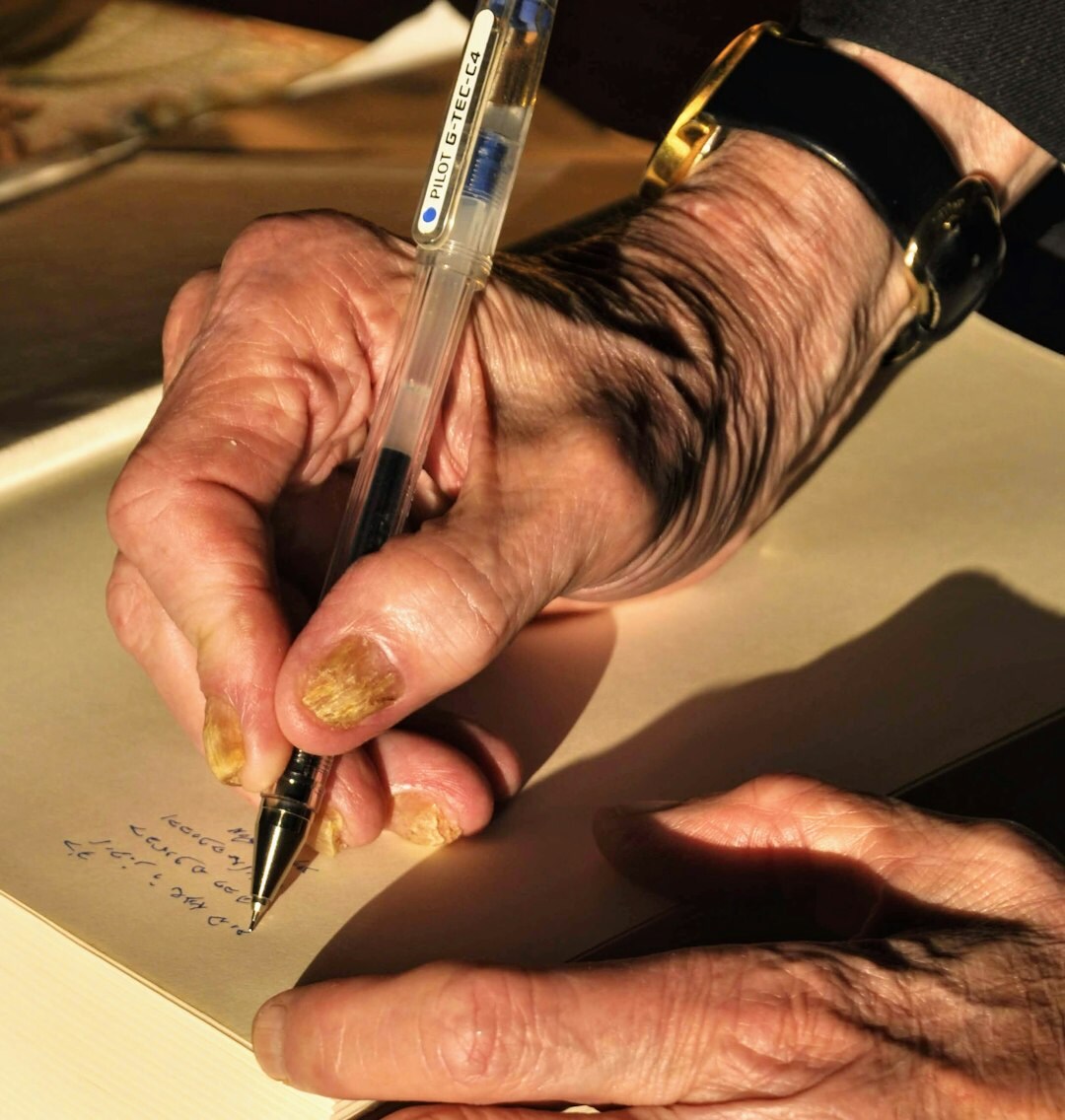 Young Brazilian woman writing thoughtfully in a journal at a desk