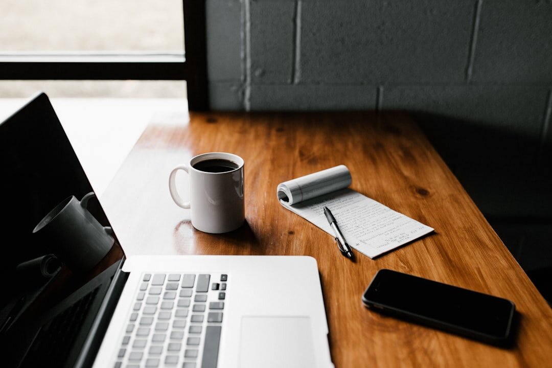 Flat lay of a notebook, headphones and coffee cup on a wooden desk