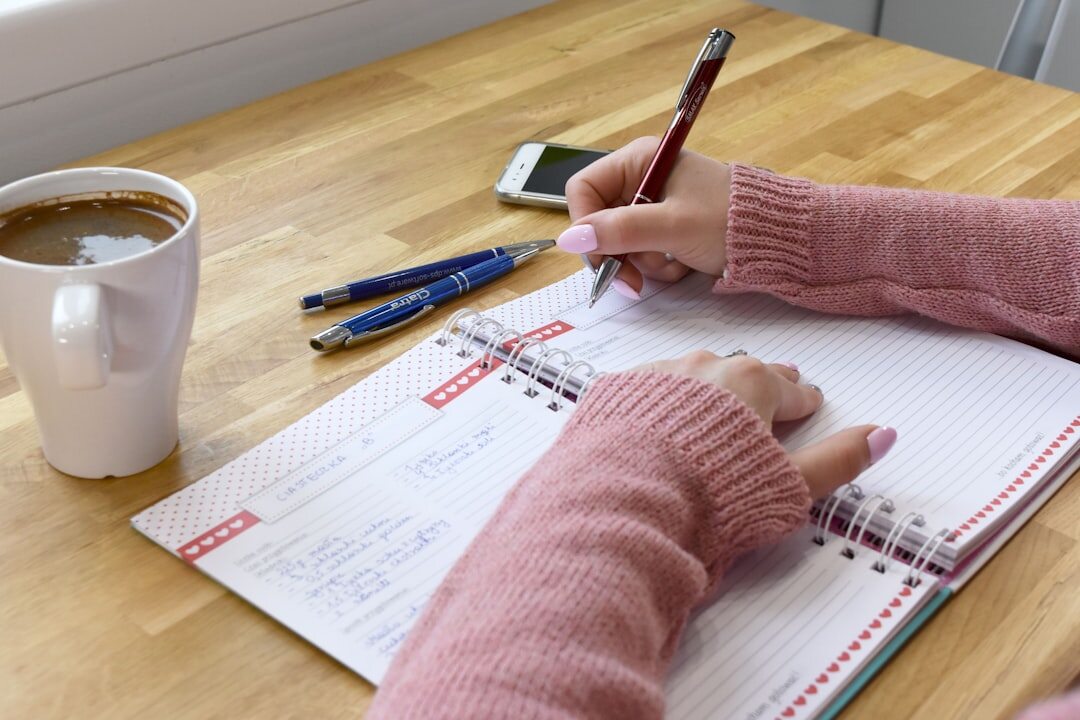 person writing notes in journal